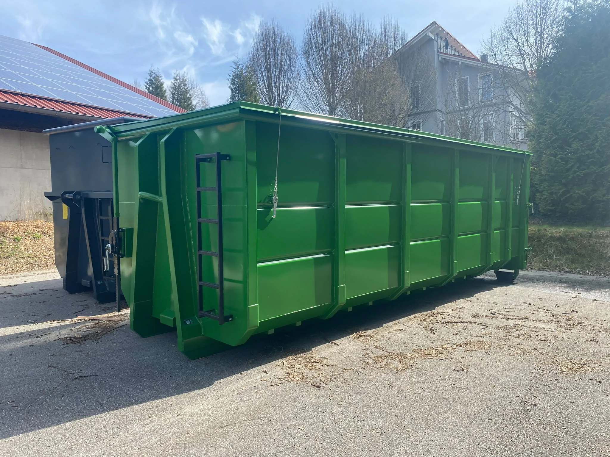 Grüner hoher Abrollcontainer mit Abdeckung