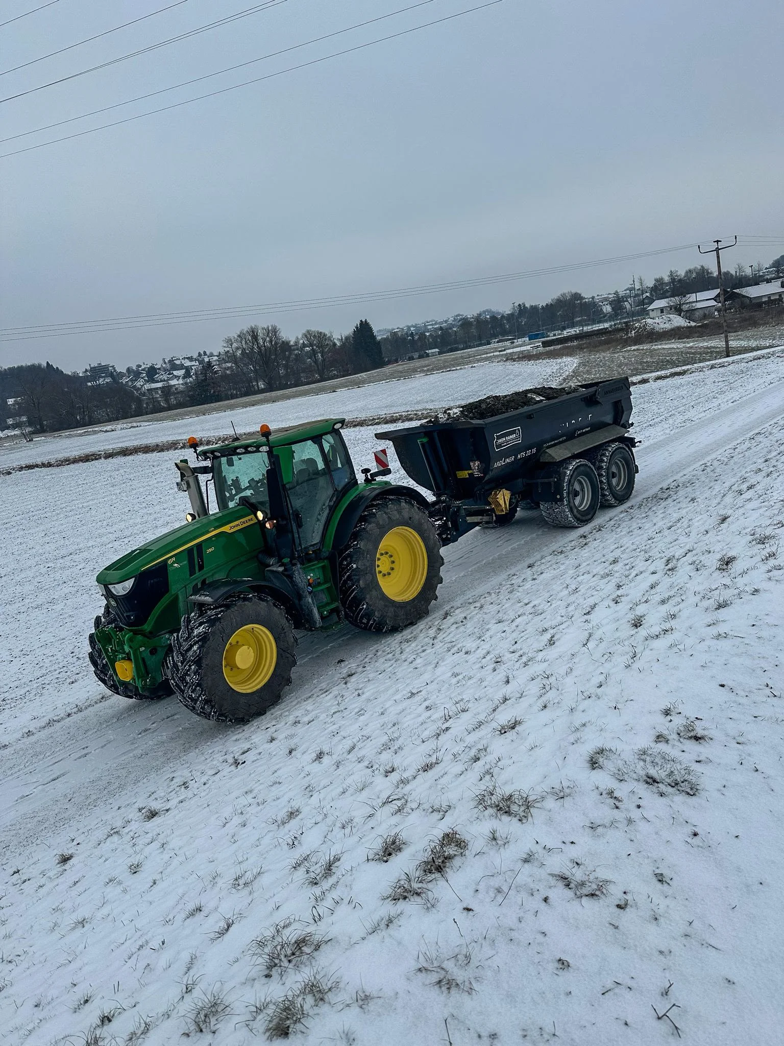 John Deere mit beladener Annaburger Erdmulde im Winter