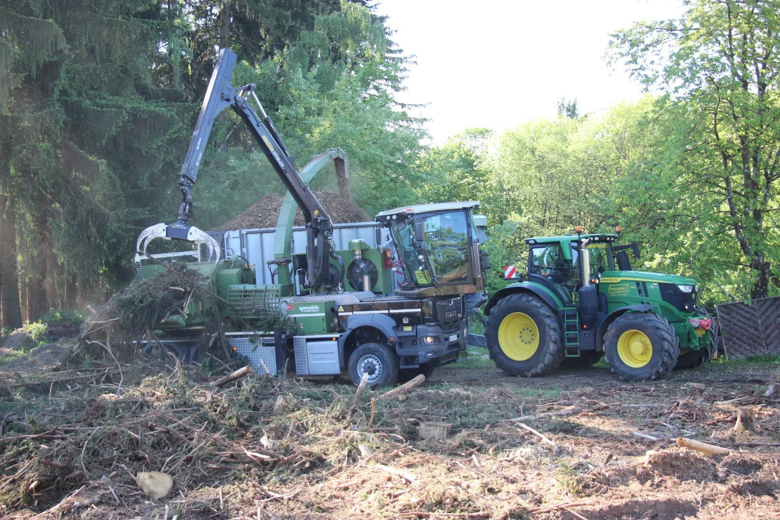 Pezzolato-Holzhacker und John-Deere-Traktor bei der Hackschnitzelerzeugung