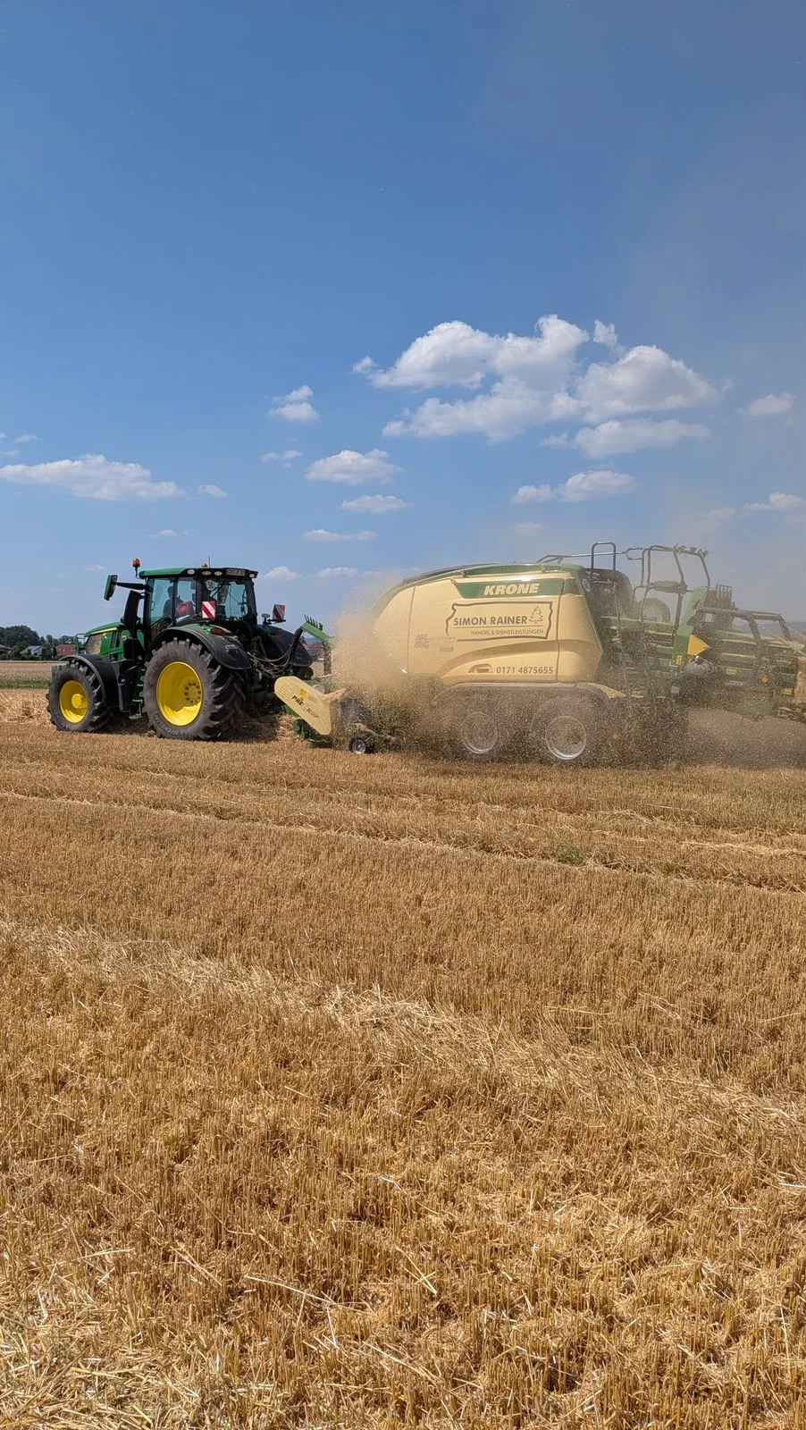 John-Deere-Traktor und komplette Krone-Quaderballenpresse auf dem Stoppelfeld
