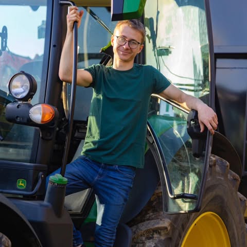 Simon Rainer, Ihr persönlicher Ansprechpartner, an seinem John-Deere-Traktor